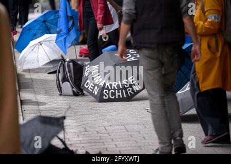 Hambourg, Allemagne. 27 mai 2021. « crise climatique sur le parapluie » est écrit sur le parapluie qui se trouve sur le sol, devant une manifestation. Divers groupes locaux de la rébellion des extinction ont appelé à un meilleur reportage sur la crise climatique dans des actions décentralisées devant les médias sous le slogan "crise climatique sur la première page". Credit: Jonas Walzberg/dpa/Alay Live News Banque D'Images