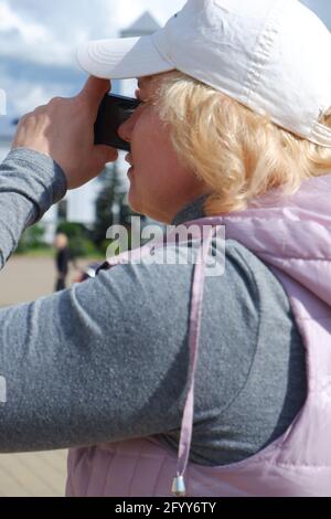 La fille prend des photos du paysage de la ville. Journée des photographes de la Saint-Veronica . Banque D'Images