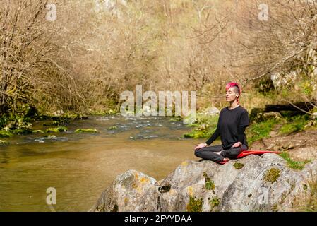 Jeune femme indépendante afro-américaine concentrée avec une tasse de café vous pouvez vous asseoir sur un canapé et parcourir votre ordinateur portable tout en travaillant à distance sur le projet à h Banque D'Images