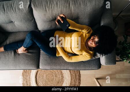 Vue de dessus de la bonne Afro-américaine femme prenant autoportrait avec téléphone portable sur un canapé Banque D'Images
