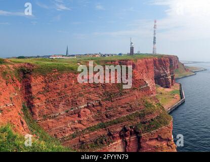 Vue sur les falaises de Rusty et le phare de la L'île de la Mer du Nord à Helgoland pour une Sunny journée d'été avec Un ciel bleu clair et quelques nuages Banque D'Images