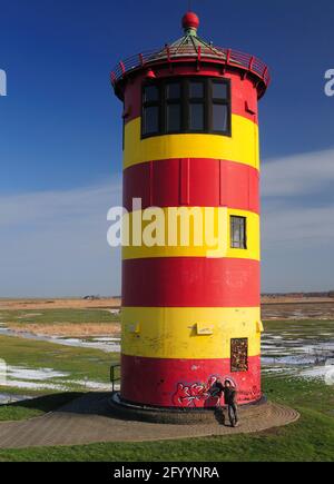 Le célèbre Phare jaune rouge de Pilsum dans le National Parc de la Mer des Wadden Frise orientale lors D'UNE Sunny hiver Avec UN ciel bleu clair Banque D'Images