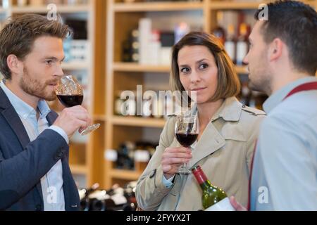 couple pendant une dégustation de vin avec un sommelier les aidant Banque D'Images