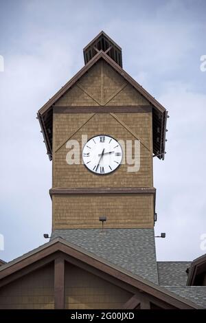 Plan vertical d'une tour d'horloge en briques orange-brunes et avec un toit en forme de triangle. Banque D'Images