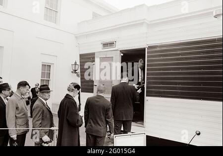 Les visiteurs attendent en file devant une remorque installée près de l'entrée de l'aile est de la Maison Blanche pour laisser leurs caméras, sacs à main et colis pour inspection, dans le cadre des nouvelles mesures de sécurité établies en réponse à la crise à Cuba. Washington, D.C.. 23 octobre 1962 Banque D'Images