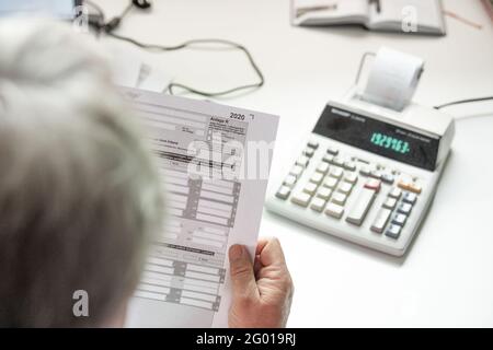 Bad Oeynhausen, Allemagne. 29 mai 2021. ILLUSTRATION - UN pensionné remplit sa déclaration de revenus et saisit des numéros dans une calculatrice de bureau pour la calculer. La Cour fédérale de l'exercice annoncera des décisions dans deux affaires concernant l'imposition des pensions sur Momtag (31.05.2021). La question est de savoir si le gouvernement fédéral impose à tort deux fois les pensions. (À 'la Cour fiscale fédérale annonce des décisions de retraite - effets majeurs possibles') Credit: Lino Mirgeler/dpa/Alamy Live News Banque D'Images