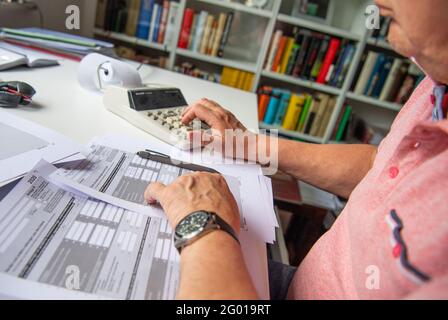 Bad Oeynhausen, Allemagne. 29 mai 2021. ILLUSTRATION - UN pensionné remplit sa déclaration de revenus et saisit des numéros dans une calculatrice de bureau pour la calculer. La Cour fédérale de l'exercice annoncera des décisions dans deux affaires concernant l'imposition des pensions sur Momtag (31.05.2021). La question est de savoir si le gouvernement fédéral impose à tort deux fois les pensions. (À 'la Cour fiscale fédérale annonce des décisions de retraite - effets majeurs possibles') Credit: Lino Mirgeler/dpa/Alamy Live News Banque D'Images