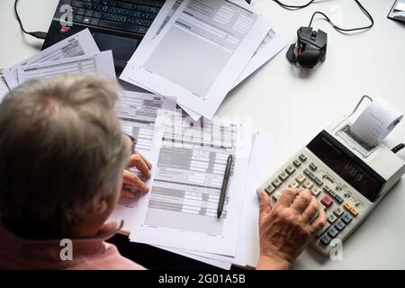 Bad Oeynhausen, Allemagne. 29 mai 2021. ILLUSTRATION - UN pensionné remplit sa déclaration de revenus et saisit des numéros dans une calculatrice de bureau pour la calculer. La Cour fédérale de l'exercice annoncera des décisions dans deux affaires concernant l'imposition des pensions sur Momtag (31.05.2021). La question est de savoir si le gouvernement fédéral impose à tort deux fois les pensions. (À 'la Cour fiscale fédérale annonce des décisions de retraite - effets majeurs possibles') Credit: Lino Mirgeler/dpa/Alamy Live News Banque D'Images