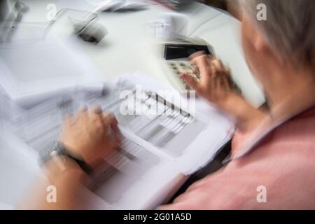 Bad Oeynhausen, Allemagne. 29 mai 2021. ILLUSTRATION - UN pensionné remplit sa déclaration de revenus et saisit des numéros dans une calculatrice de bureau pour la calculer (photo avec effet de balayage). La Cour fédérale de l'exercice annoncera des décisions dans deux affaires d'imposition des pensions sur Momtag (31.05.2021). La question est de savoir si le gouvernement fédéral est à tort en double imposition des pensions. (À 'la Cour fiscale fédérale annonce des décisions de retraite - impact majeur possible') crédit: Lino Mirgeler/dpa/Alamy Live News Banque D'Images