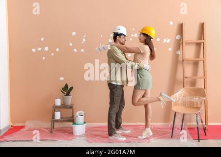 Un jeune couple heureux s'amuser pendant la réparation dans leur nouvelle maison Banque D'Images