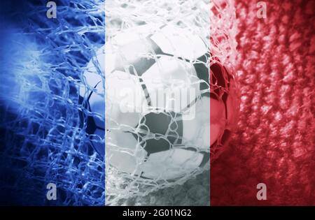 Drapeau français avec une balle de football à l'intérieur du filet. Concept de l'équipe de football de France. Banque D'Images