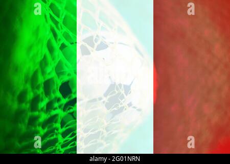 Drapeau italien avec une balle de football à l'intérieur d'un filet comme arrière-plan. Concept de l'équipe italienne de football. Banque D'Images