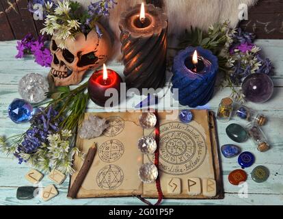 Encore la vie avec livre de sorcière ouvert, cristal, bougies et fleurs brûlantes sur table d'autel. Arrière-plan ésotérique, gothique et occulte, mystique d'Halloween et wic Banque D'Images