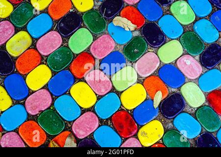 Vue de dessus sur des morceaux de carreaux de céramique multicolores décorés dans le jardin. Vieux pavé de tuiles texturées. Trottoir pavé de mosaïque de rue. Résumé, bac Banque D'Images