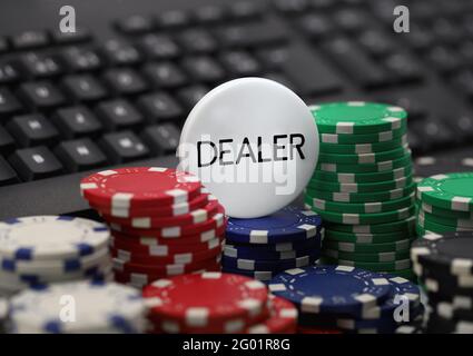 puce de revendeur sur les jetons de poker devant le clavier d'ordinateur, image de concept de casinos en ligne, dépendance de jeu Banque D'Images
