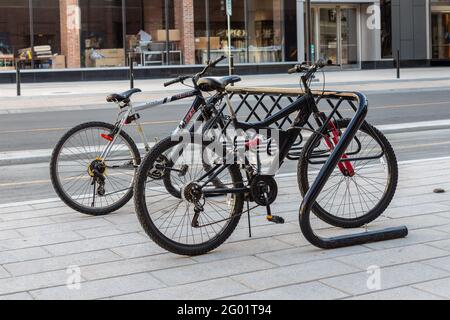 Ottawa, Canada le 23 mai 2021 : porte-vélos pour le stationnement des bicyclettes dans la rue du centre-ville. Stand Bycycle avec véhicules verrouillés sur la chaussée près de la route dans le Banque D'Images