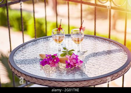 Apéritif d'été composé de cocktails maison et de fleurs roses de bougainvilliers sur une table en verre. Concept de rafraîchissement. Copier l'espace. En été, fleurs surréalistes et boissons maison. Copier l'espace. Haute qualité Banque D'Images