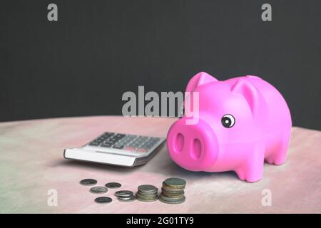 Tirelire, calculatrice et argent sur table. Copier l'espace. Banque D'Images