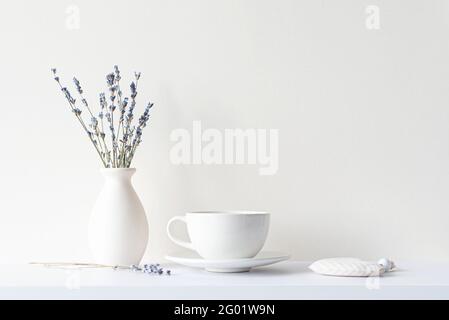 Encore plus de vie avec une composition minimale, bouquet de lavande séché, tasse blanche en céramique et boisson chaude thé ou café, humeur du matin dans un ton beige Banque D'Images