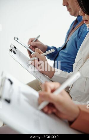 Image rognée des candidats à un poste remplissant les données dans les formulaires de cv en attendant un entretien avec le responsable des ressources humaines Banque D'Images