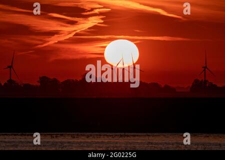 Coucher de soleil derrière le parc éolien de Tick Fen, de l'autre côté des niveaux de Bedford Banque D'Images