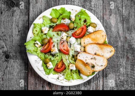 Salade de légumes avec feta, tomates et laitue, régime alimentaire sain, nourriture végétarienne sur l'assiette, au-dessus Banque D'Images