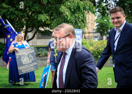 Mark Francois, député du Parti conservateur britannique, traverse College Green avec des manifestants pro-européens en arrière-plan, Londres, Royaume-Uni Banque D'Images