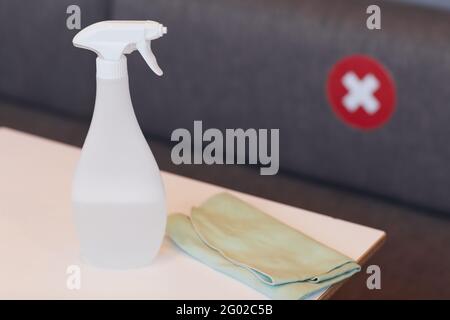 Image d'arrière-plan du vaporisateur d'assainisseur sur la table du café avec un autocollant de distance sociale, concept de sécurité des covid, espace de copie Banque D'Images