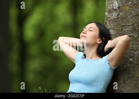 Femme asiatique se reposant sur un arbre dans un parc ou forêt Banque D'Images