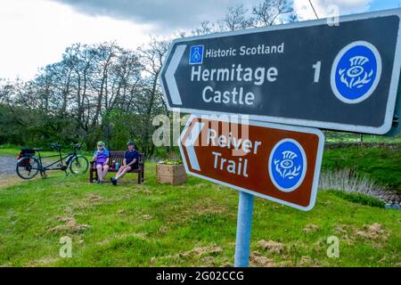 Un couple en tandem s'arrête pour prendre un verre près du château d'Hermitage dans la vallée de Liddesdale, Newcastleton, aux frontières écossaises. Banque D'Images