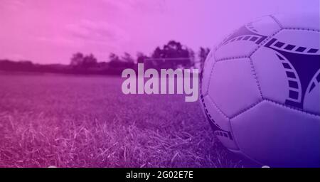 Composition du football sur une ligne blanche sur un terrain de pelouse avec espace de copie et teinte violette Banque D'Images