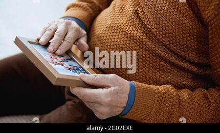 vue rapprochée des mains de hommes âgés qui touchent doucement la famille image sur fond gris Banque D'Images