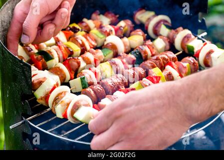 Brochettes de viande de légumes et saucisses grillées sur le barbecue, les gens grillent des aliments à l'extérieur Banque D'Images