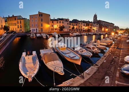 FRANCE - BOUCHES DU RHÔNE - 13 - MARTIGUES : LE CANAL DE SAN SEBASTIAN AU CRÉPUSCULE. EN ARRIÈRE-PLAN, LE QUAI MARCEAU ET L'ÉGLISE PAROISSIALE DE MARTIGUES. Banque D'Images