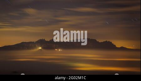 Montagne de Montserrat la nuit au-dessus d'une mer de nuages, vue du sommet de Turó de la Pola (Barcelone, Catalogne, Espagne) Banque D'Images