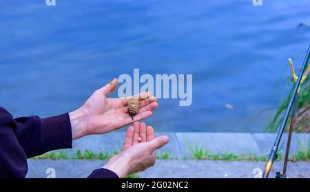 pêche sur la rivière un homme met un appât pour attraper des poissons, foyer sélectif. Banque D'Images