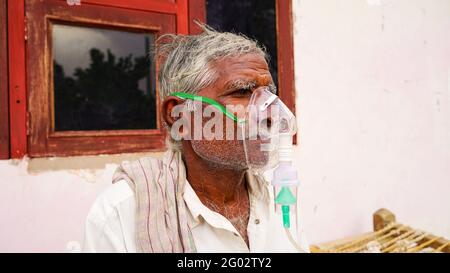 20 mai 2021 - Reengus, Sikar, Inde. Personne aînée infectée par la maladie de Covid 19. Patient inhalant de l'oxygène porter un masque avec un flux d'oxygène liquide. Banque D'Images