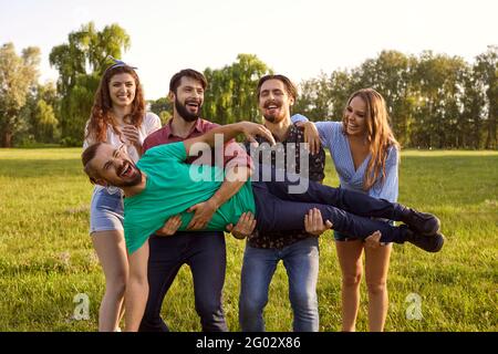 Amis joueurs s'amusant ensemble dans le parc Banque D'Images