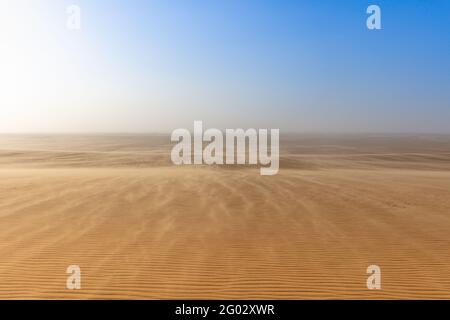 Grand désert du Sahara avec le ciel bleu sur l'horizont. Banque D'Images