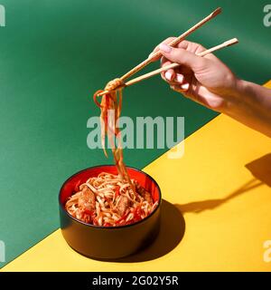 Faire sauter les nouilles soba avec le bœuf et les légumes dans le wok sur fond sombre, les nouilles udon asiatiques avec LE WOK de bœuf dans un bol noir sur fond ardoise. Copier Banque D'Images