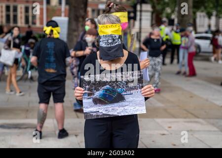 LONDRES, Royaume-Uni – Circa septembre 2020 : les manifestants de la rébellion de l'extinction tiennent des images des catastrophes naturelles causées par le changement climatique au cours d'une manifestation Banque D'Images