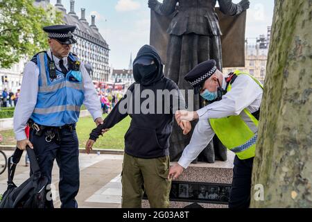 LONDRES, Royaume-Uni – deux officiers de la police métropolitaine effectuent une fouille corporelle et arrêtent un manifestant de la rébellion en voie d'extinction lors d'une manifestation. Banque D'Images