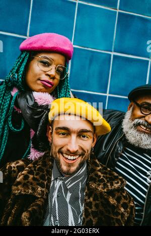 Portrait d'un jeune homme souriant avec des amis portant des bérets Banque D'Images