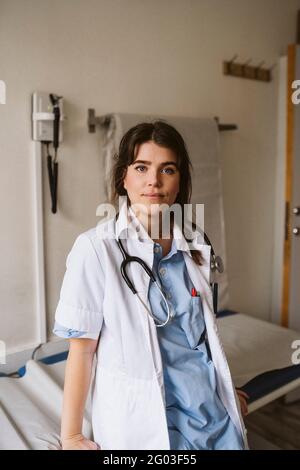 Portrait d'une travailleuse de santé penchée sur une table d'examen à la clinique médicale Banque D'Images