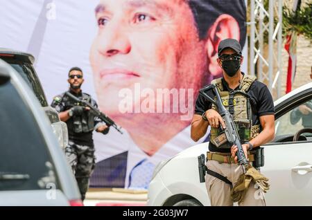 Gaza, Palestine. 31 mai 2021. Un membre de la sécurité égyptienne est assuré par une bannière montrant le président Abdel Fattah al-Sisi lors d'une réunion entre le chef des services de renseignement égyptiens et les responsables du Hamas à Gaza. Le général Abbas Kamel se réunit à Gaza le 31 mai 2021. m. kamel effectue une visite officielle en Israël et dans les territoires palestiniens pour donner suite à l’accord de cessez-le-feu négocié par l’Égypte entre les groupes armés palestiniens et Israël. Crédit : SOPA Images Limited/Alamy Live News Banque D'Images