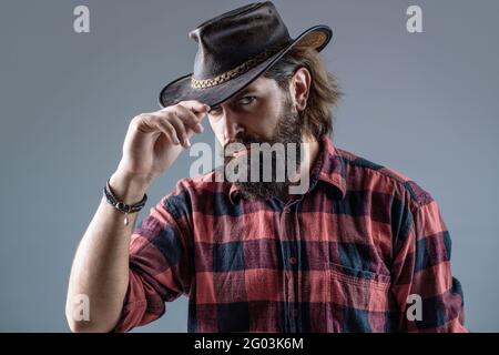 Cow-boys non rasés. Cow-boy américain. Chapeau de cowboy en cuir. Portrait d'un jeune homme portant un chapeau de cow-boy. Cowboys en chapeau. Jolie macho barbu Banque D'Images