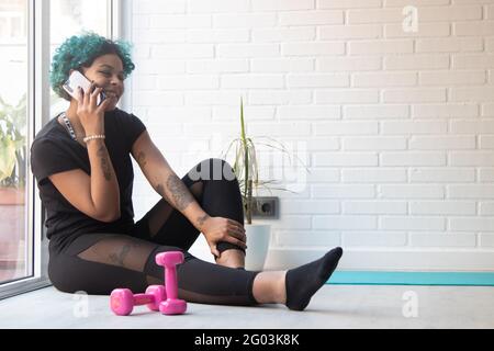 fille ou femme à la maison ou à la salle de sport faisant du sport avec téléphone portable Banque D'Images