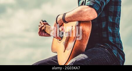 Les mains de l'homme jouant de la guitare acoustique, gros plan. Guitares acoustiques en train de jouer. Concept de musique Banque D'Images