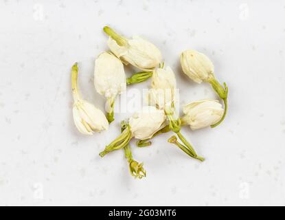 plusieurs fleurs de jasmin séchées se ferment sur une plaque en céramique grise Banque D'Images