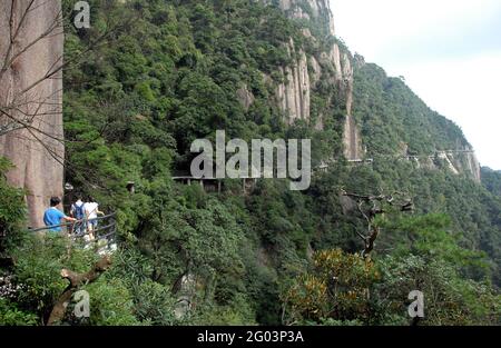 Montagne Sanqingshan dans la province de Jiangxi, Chine. Les gens qui marchent le long d'un chemin accroché à la falaise en haut sur le mont Sanqing. Banque D'Images